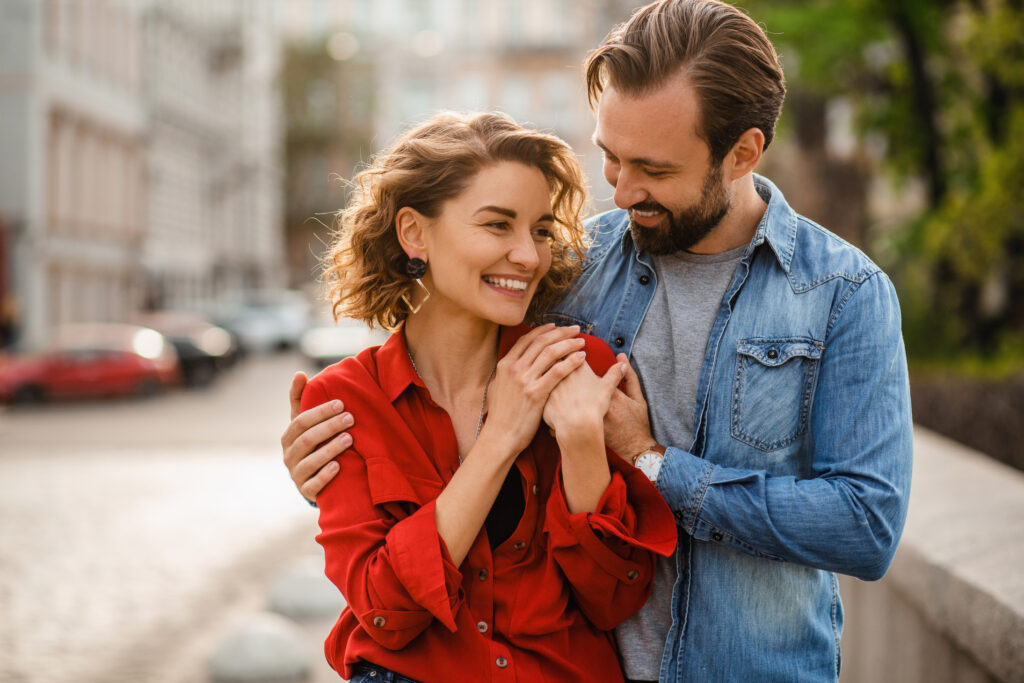 attractive happy smiling man and woman in love traveling together in Europe, stylish couple in love walking embracing in street on romantic trip, sunny summer city, having fun, tenderness