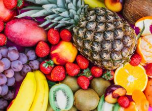 Assiette colorée de fruits frais comprenant des raisins, des fraises et de l’ananas, illustrant une alimentation saine et équilibrée.