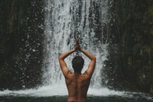 Personne méditant face à une cascade, illustrant l’équilibre entre introversion et extraversion chez un ambiverti.