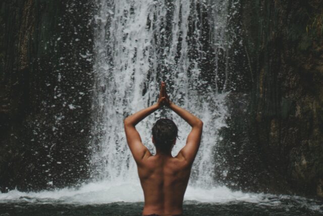 Personne méditant face à une cascade, illustrant l’équilibre entre introversion et extraversion chez un ambiverti.