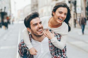 Couple heureux riant dans la rue illustrant une relation saine et épanouie