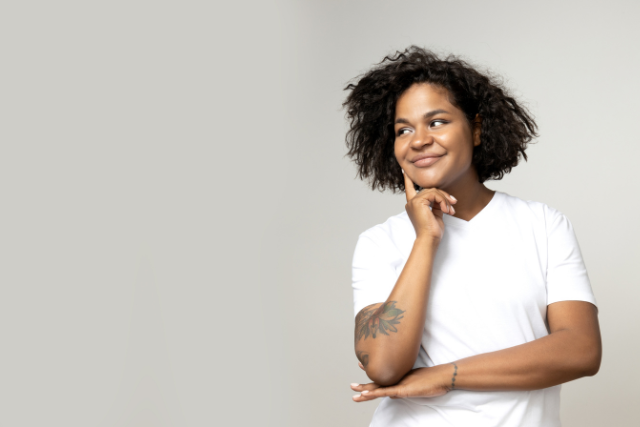 Personne réfléchissant avec le sourire, illustrant la question suis-je introverti ou extraverti et la compréhension de son fonctionnement relationnel.